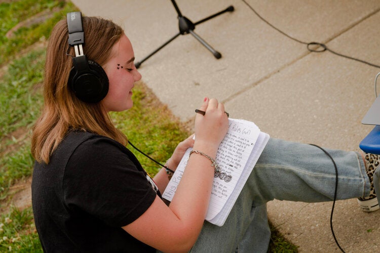 Girl with headphones writing, Mobile Studio Workshop.jpg