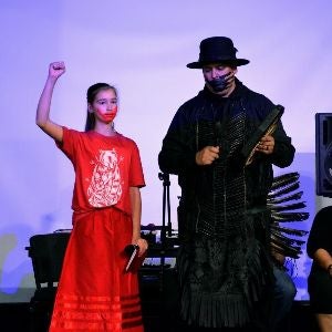 Young female Native American raises fist at poetry reading, Indigenous PopX 2019, McNichols Building 300
